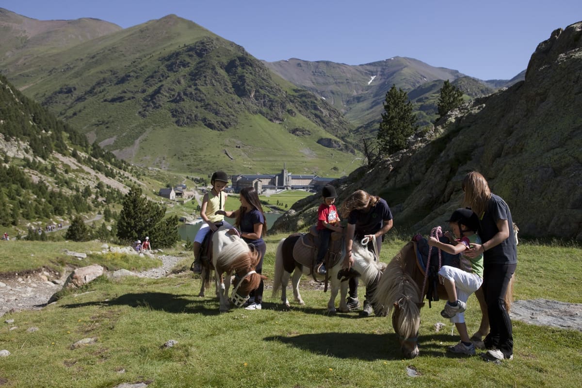 Monitors ajudant els nens amb ponis / Instructores ayudando a los niños con los ponis